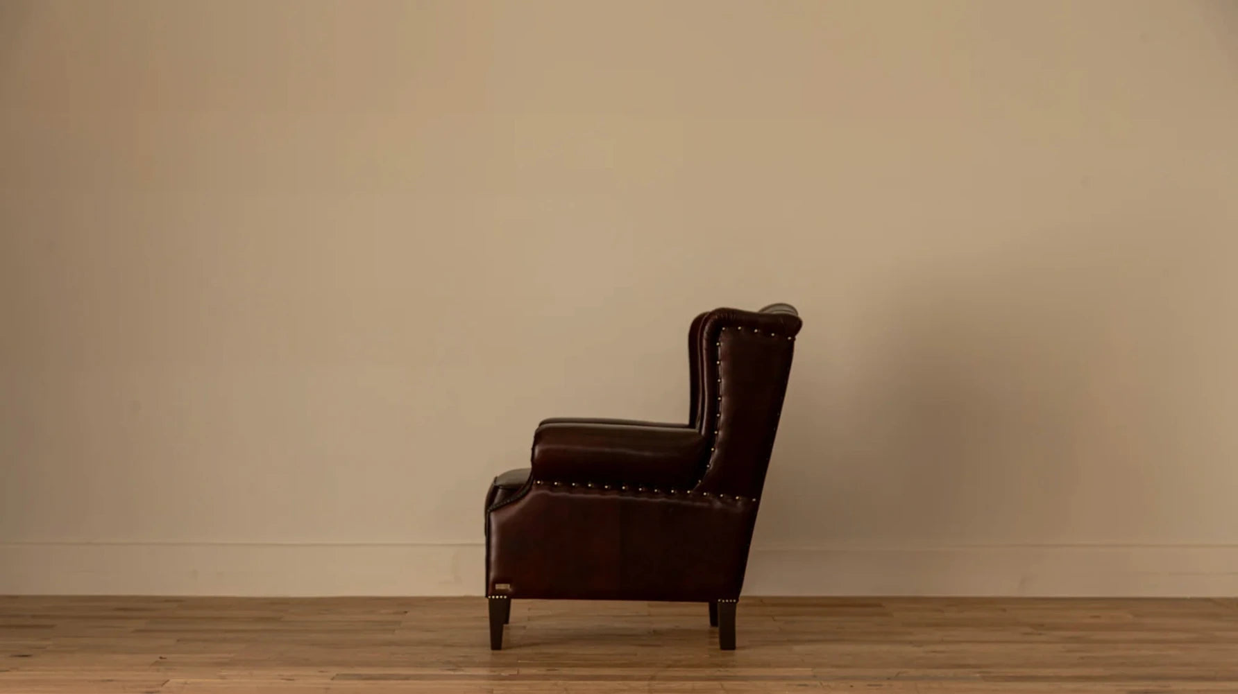 Side view (alt): "Side view of the James Chesterfield armchair highlighting its tall wing back and nailhead-trimmed silhouette.