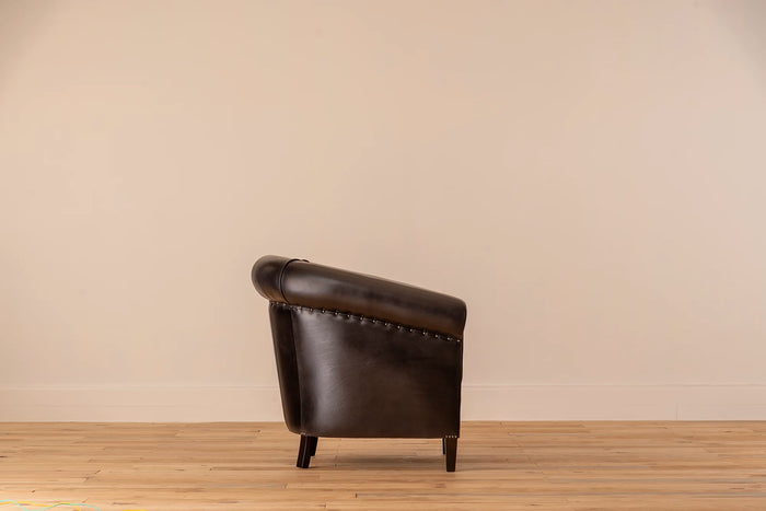 Black leather armchair against a beige wall