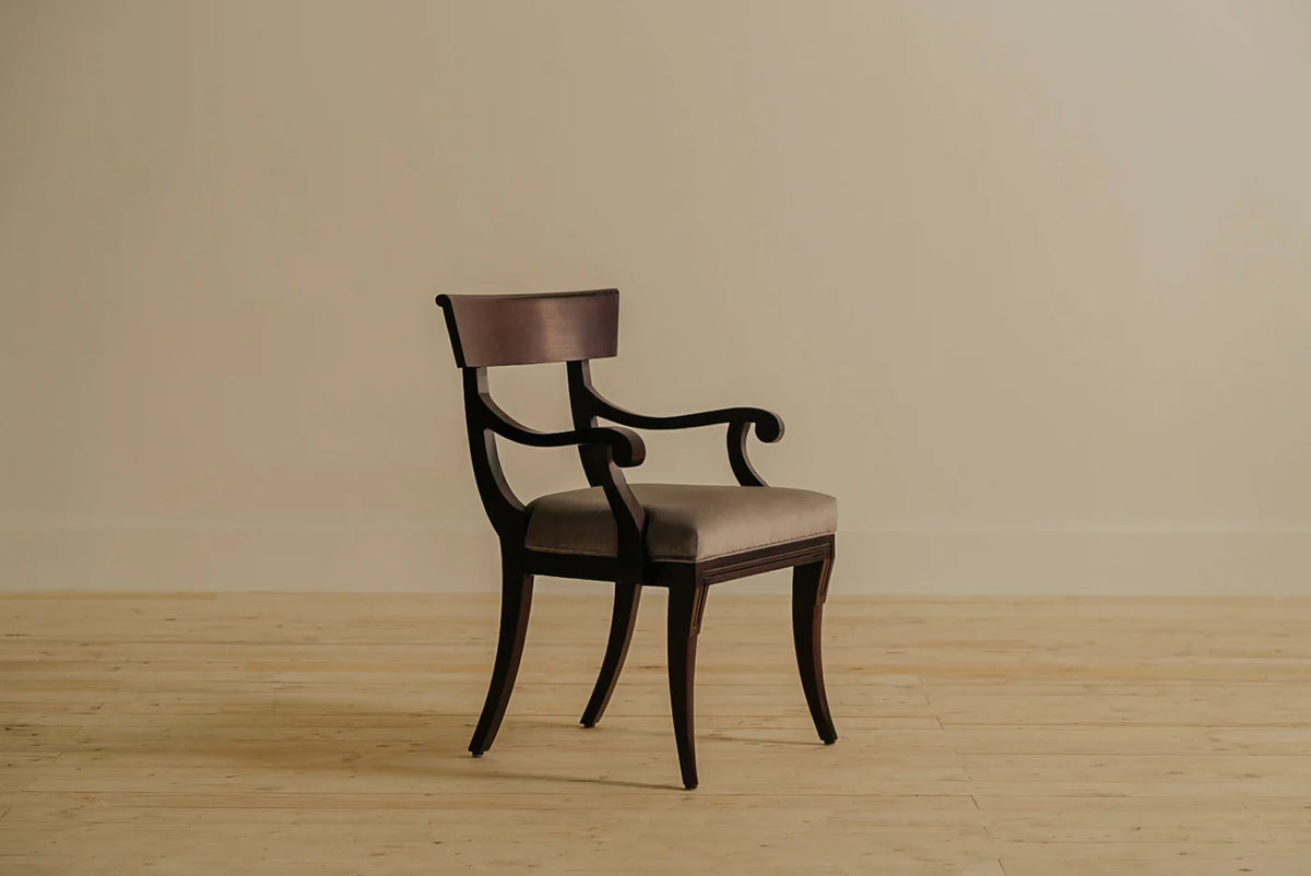 Crown dining armchair with scrolled arms and a slightly wider seat, crafted in aged mahogany with a natural finish. Upholstered in 100% French Twill Cotton, handcrafted by Chester's India