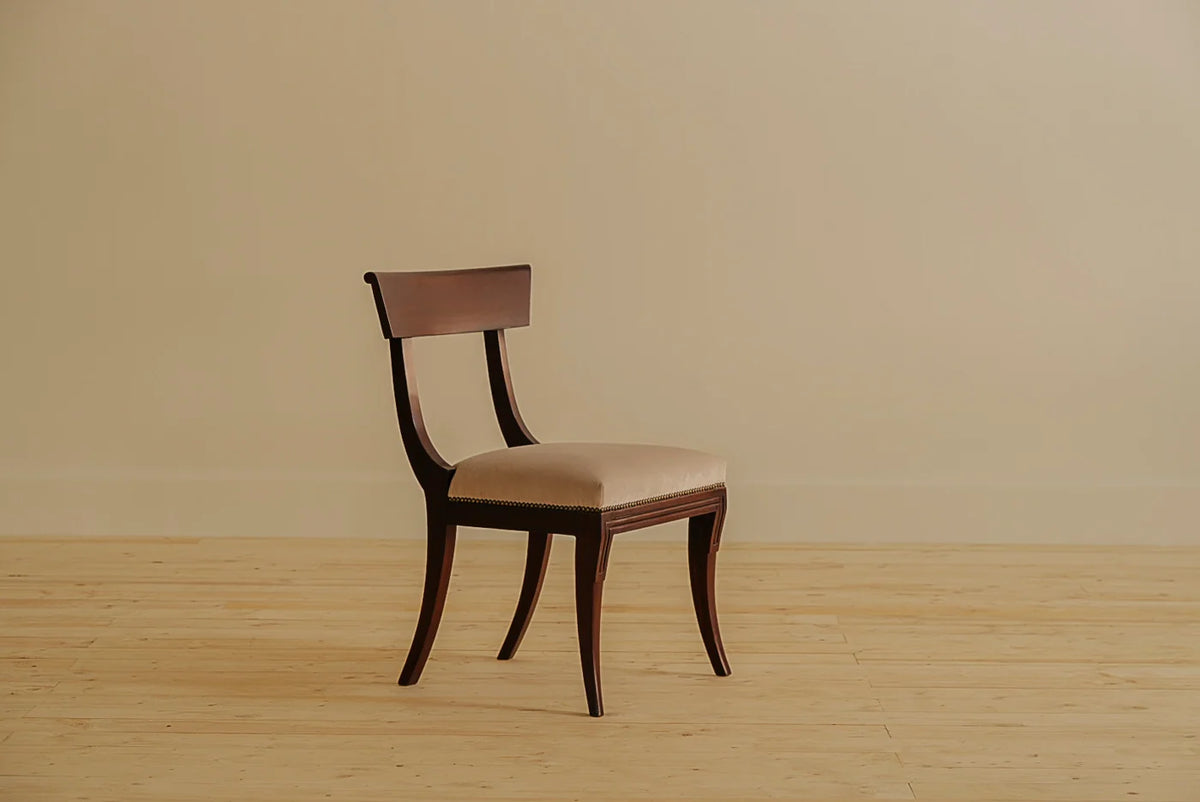 Crown dining chair with Regency-inspired sweeping vertical curves and a gently enveloping crown-head back, crafted in aged mahogany. Upholstered in 100% French Twill Cotton, handcrafted by Chester's India.