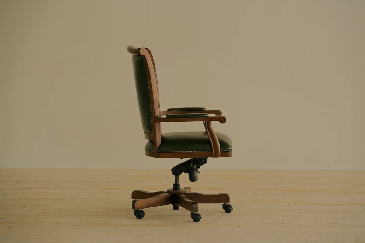Heritage Swivel Chair by Chester’s India in Shadow Bottle Green leather, with an exposed solid-teak frame and a classic swivel base.